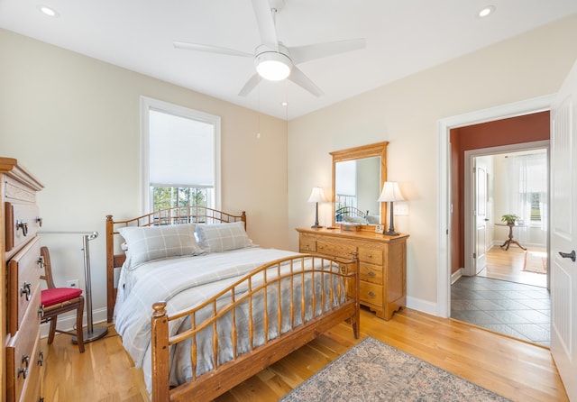 bedroom with recessed lighting, light wood-type flooring, baseboards, and a ceiling fan