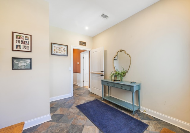 entryway with baseboards, visible vents, and stone finish flooring