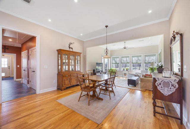 dining area with attic access, light wood-style flooring, baseboards, and ornamental molding