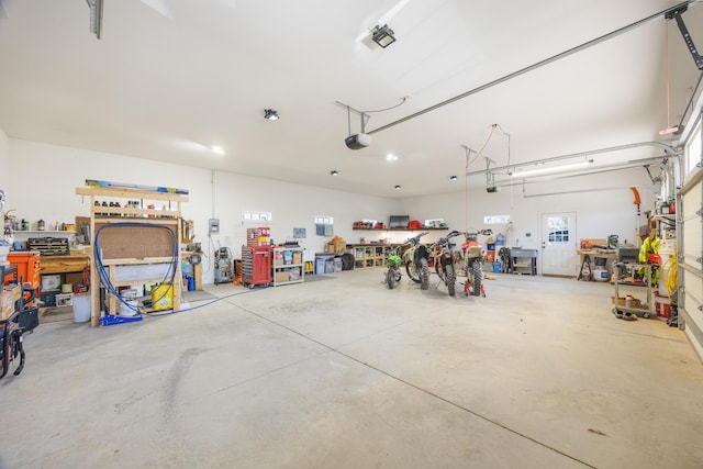 garage with a workshop area and a garage door opener