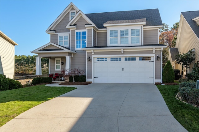 craftsman inspired home featuring a garage and a front lawn