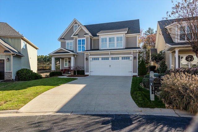 craftsman inspired home featuring a garage and a front lawn