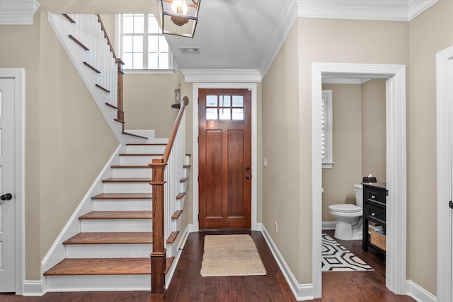 foyer with ornamental molding and dark hardwood / wood-style floors