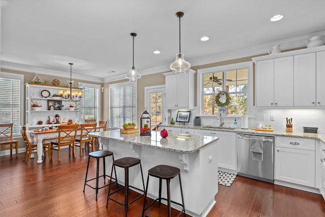 kitchen featuring dishwasher, a center island, and white cabinets