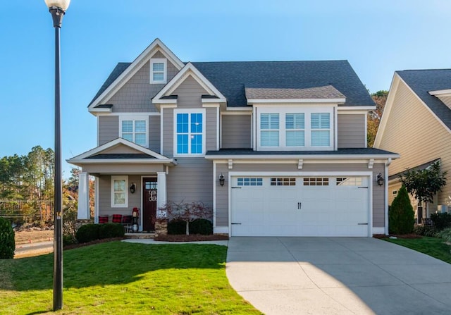 craftsman inspired home with a garage and a front lawn