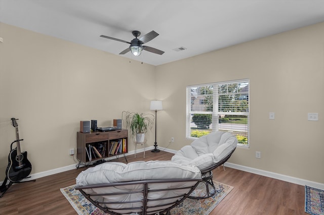 sitting room with baseboards, ceiling fan, wood finished floors, and visible vents