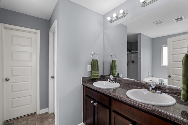 bathroom with a sink, a stall shower, and visible vents