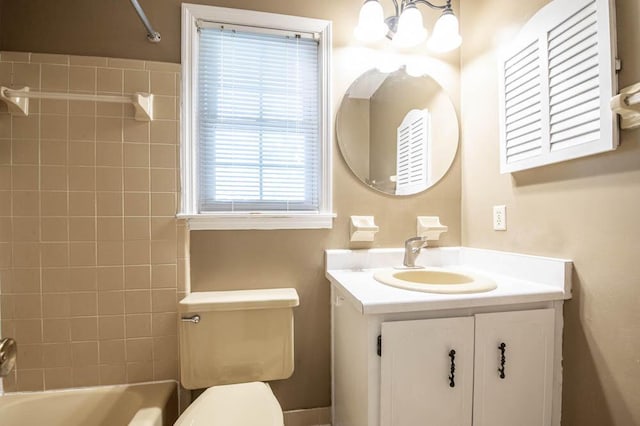 full bathroom featuring tiled shower / bath, an inviting chandelier, vanity, and toilet