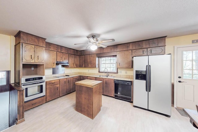 kitchen with a wealth of natural light, sink, black appliances, and a textured ceiling