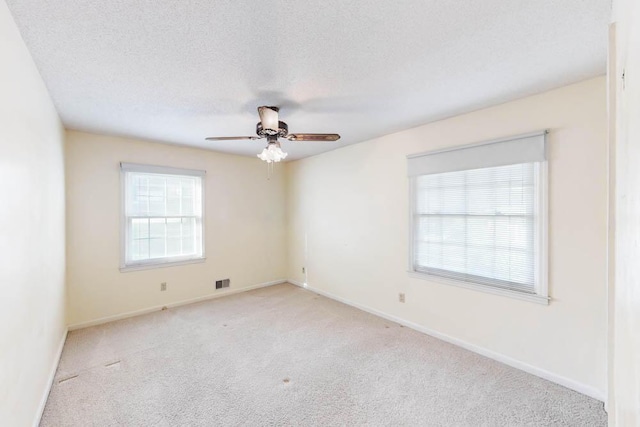 carpeted spare room with a textured ceiling and ceiling fan