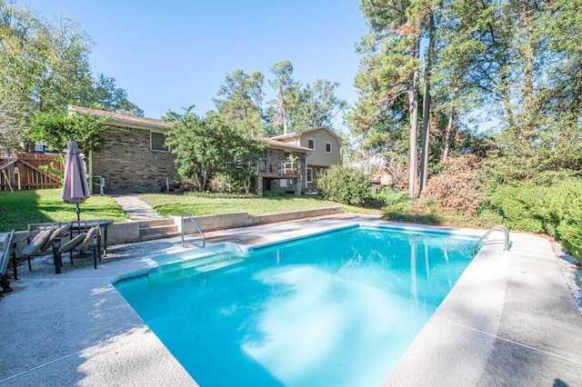 view of swimming pool with a patio area and a yard