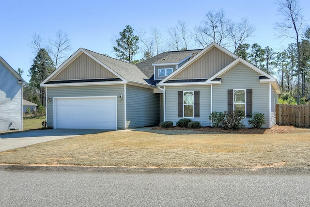 view of front of property with fence, an attached garage, a shingled roof, concrete driveway, and board and batten siding