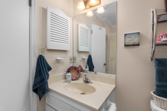 bathroom featuring toilet, crown molding, and vanity