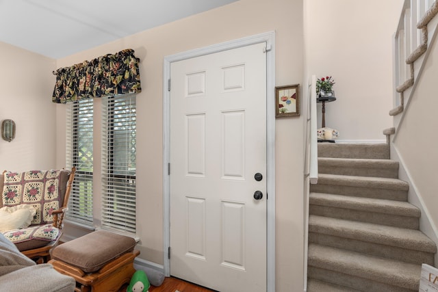 foyer with baseboards and stairs