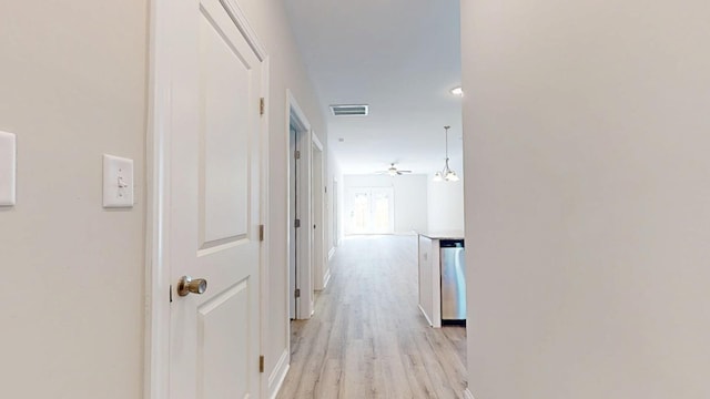 hallway featuring light wood finished floors and visible vents