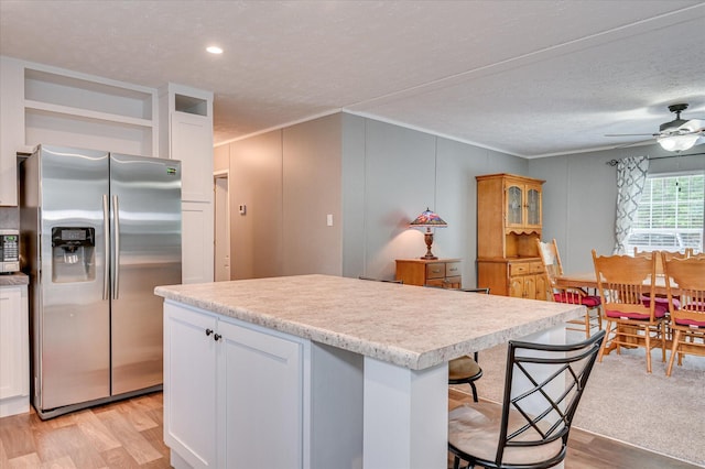 1711 Carolyn Lake Cir, Thomson, GA 30824 - kitchen featuring stainless steel fridge, light wood-style floors, ornamental molding, light countertops, and white cabinetry