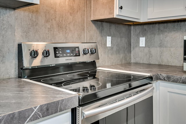 1711 Carolyn Lake Cir, Thomson, GA 30824 - kitchen featuring stainless steel electric range oven, backsplash, and white cabinetry