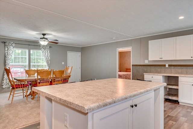 1711 Carolyn Lake Cir, Thomson, GA 30824 - kitchen with white cabinets, light countertops, crown molding, ceiling fan, and a kitchen island