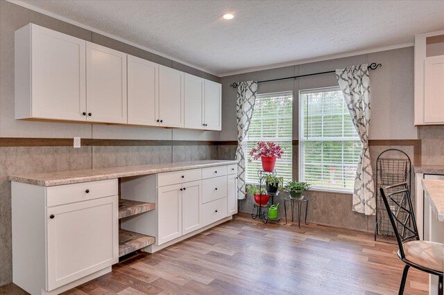 1711 Carolyn Lake Cir, Thomson, GA 30824 - kitchen with light wood-type flooring, white cabinets, light countertops, ornamental molding, and open shelves
