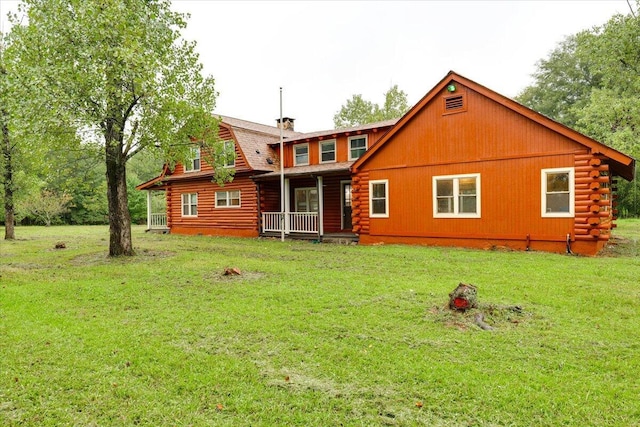 back of house with covered porch and a yard