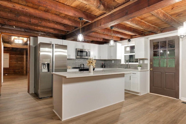 kitchen featuring pendant lighting, a kitchen island, white cabinetry, and appliances with stainless steel finishes