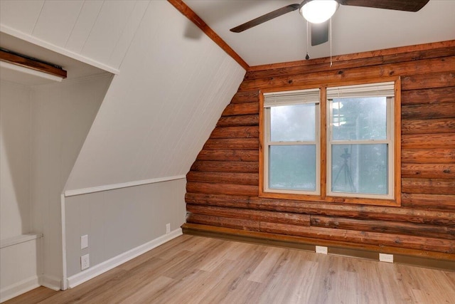 additional living space with ceiling fan, light hardwood / wood-style floors, and rustic walls