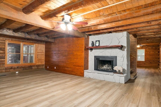 unfurnished living room with rustic walls, beamed ceiling, a fireplace, wood ceiling, and hardwood / wood-style flooring