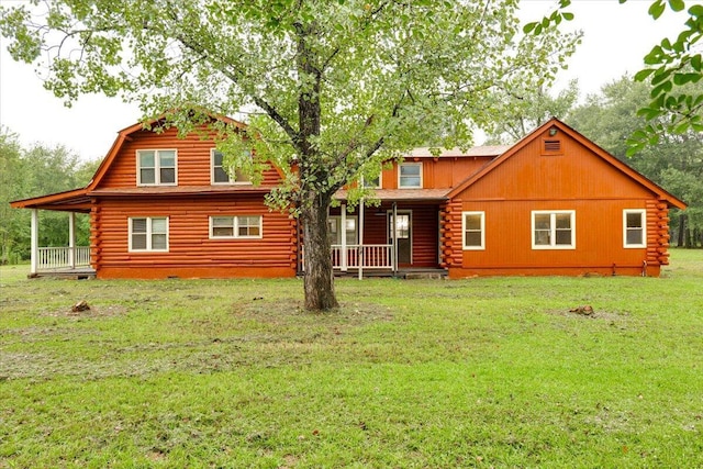 rear view of house featuring a lawn and covered porch