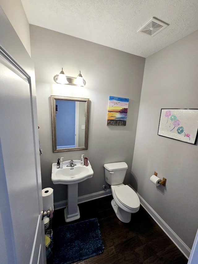 437 Arrowwood Dr, Grovetown, GA 30813 - bathroom with toilet, a textured ceiling, baseboards, wood finished floors, and visible vents