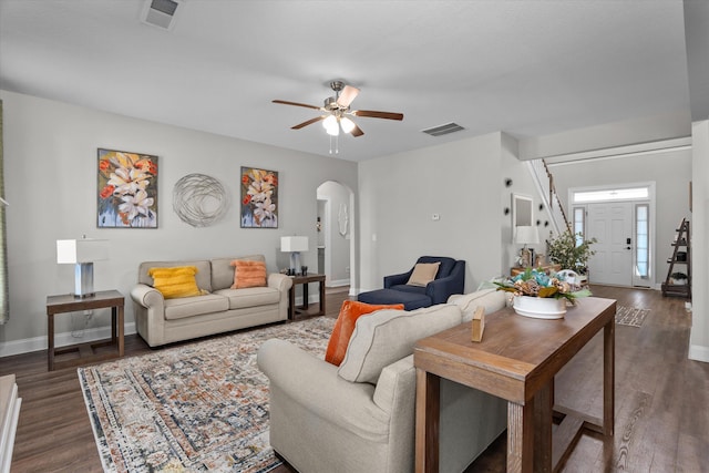 living room featuring dark wood-type flooring and ceiling fan