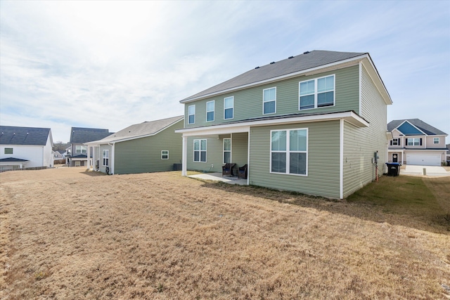 back of property featuring a lawn and a patio