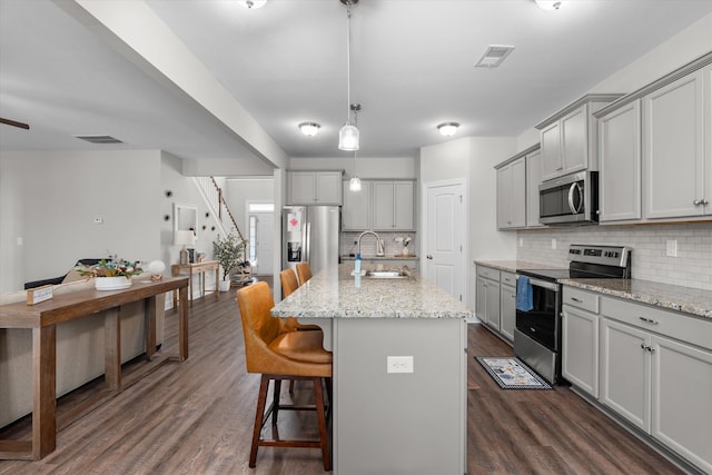 kitchen featuring gray cabinets, sink, a center island with sink, and stainless steel appliances