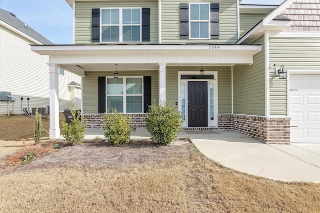 property entrance featuring covered porch, a garage, and central AC