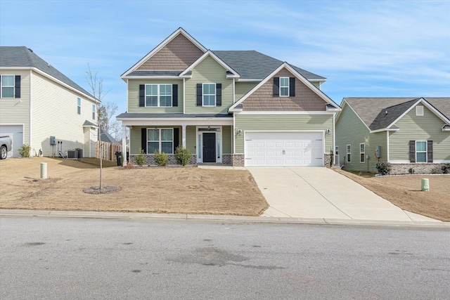 craftsman house featuring central air condition unit, a porch, and a garage