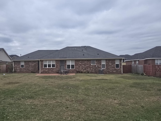 back of property with a yard, cooling unit, and a patio