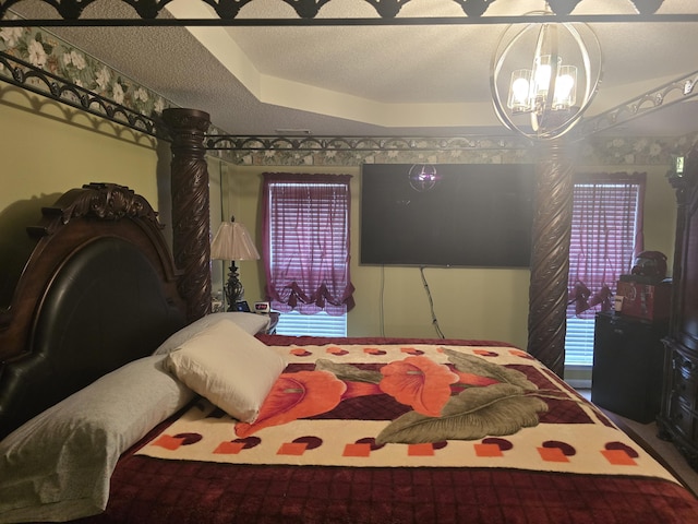 bedroom featuring a raised ceiling and a notable chandelier