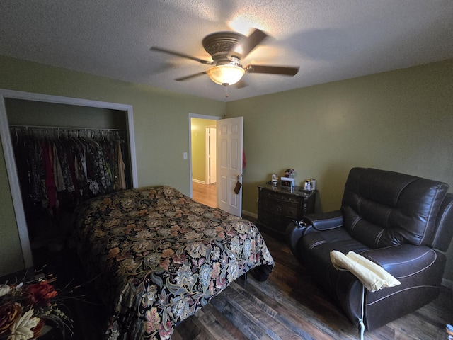 bedroom featuring a textured ceiling, dark hardwood / wood-style flooring, a closet, and ceiling fan