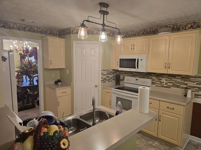 kitchen with white appliances, an inviting chandelier, hanging light fixtures, decorative backsplash, and a textured ceiling