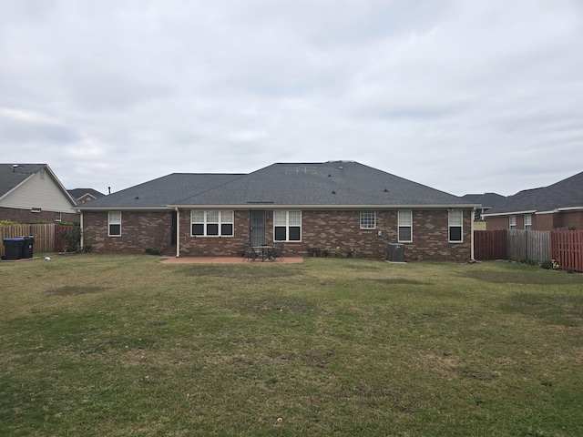 back of house with central AC unit, a patio area, and a lawn