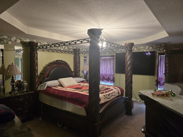 bedroom with decorative columns, a tray ceiling, and carpet floors