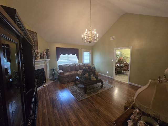 living room with dark hardwood / wood-style floors, vaulted ceiling, and a chandelier