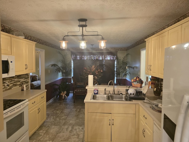 kitchen with sink, hanging light fixtures, backsplash, a textured ceiling, and white appliances