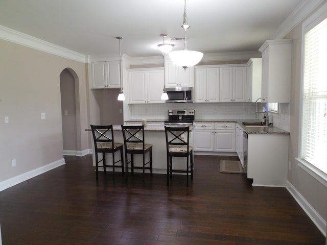 130 Clarinbridge Ln, Grovetown, GA 30813 - kitchen featuring appliances with stainless steel finishes, a sink, backsplash, arched walkways, and white cabinets
