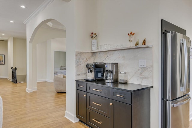 341 Crown Pt, Mccormick, SC 29835 - kitchen featuring dark countertops, light wood-type flooring, arched walkways, ornamental molding, and freestanding refrigerator