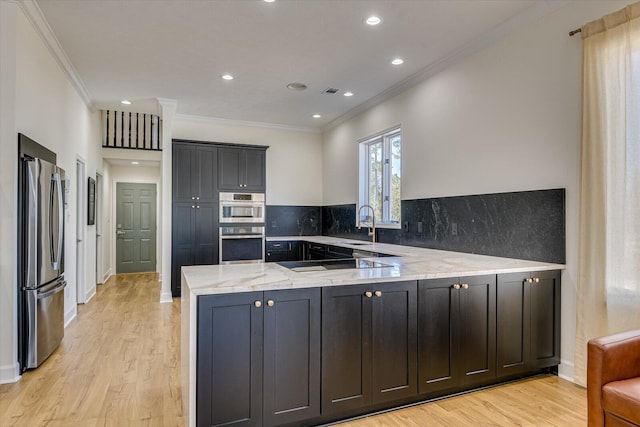 341 Crown Pt, Mccormick, SC 29835 - kitchen featuring light wood finished floors, stainless steel appliances, backsplash, light stone countertops, and a peninsula