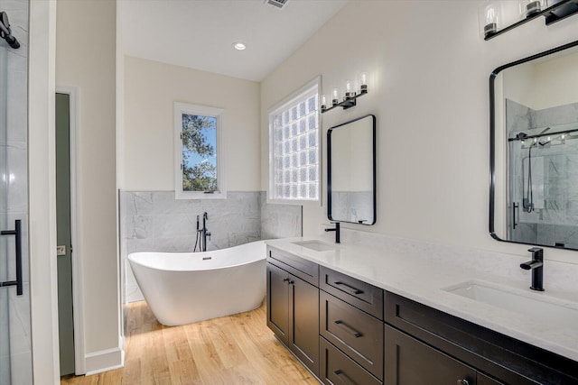 341 Crown Pt, Mccormick, SC 29835 - bathroom featuring a soaking tub, wood finished floors, a sink, and a stall shower