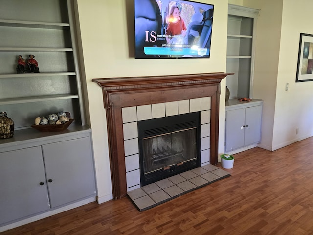 6712 Janes Rd, Appling, GA 30802 - unfurnished living room featuring wood finished floors, a tile fireplace, and built in shelves