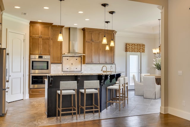 151 Commonwealth Way, Aiken, SC 29803 - kitchen featuring stainless steel appliances, wall chimney range hood, crown molding, tasteful backsplash, and brown cabinets