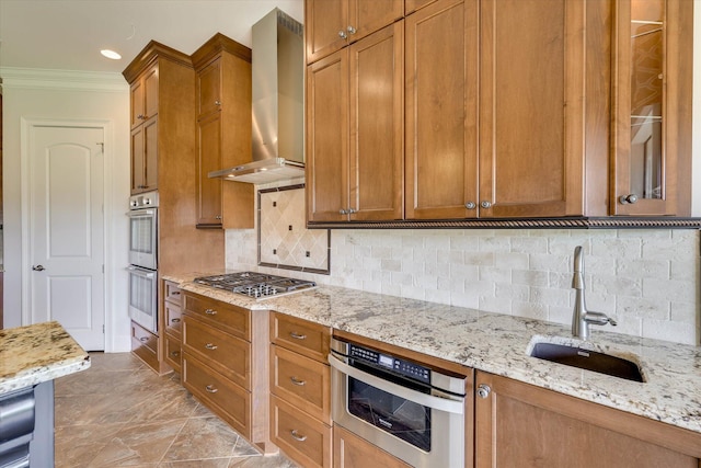 151 Commonwealth Way, Aiken, SC 29803 - kitchen with appliances with stainless steel finishes, wall chimney exhaust hood, crown molding, brown cabinetry, and light stone counters