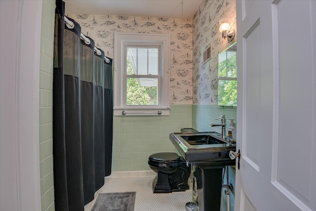 full bath featuring wallpapered walls, wainscoting, a sink, tile patterned floors, and toilet